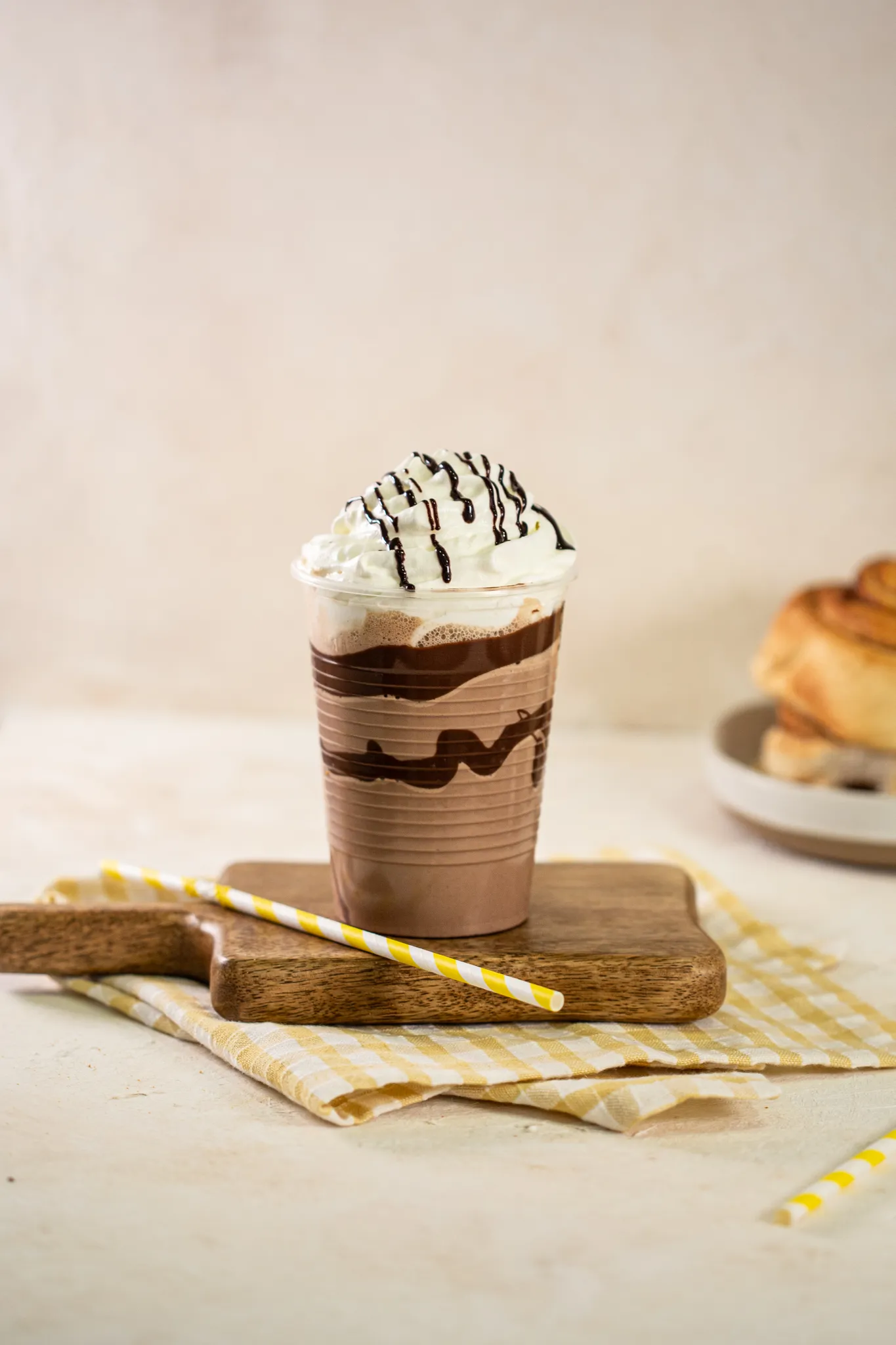 Batido de chocolate con nata en vaso alto, sobre una tabla de madera