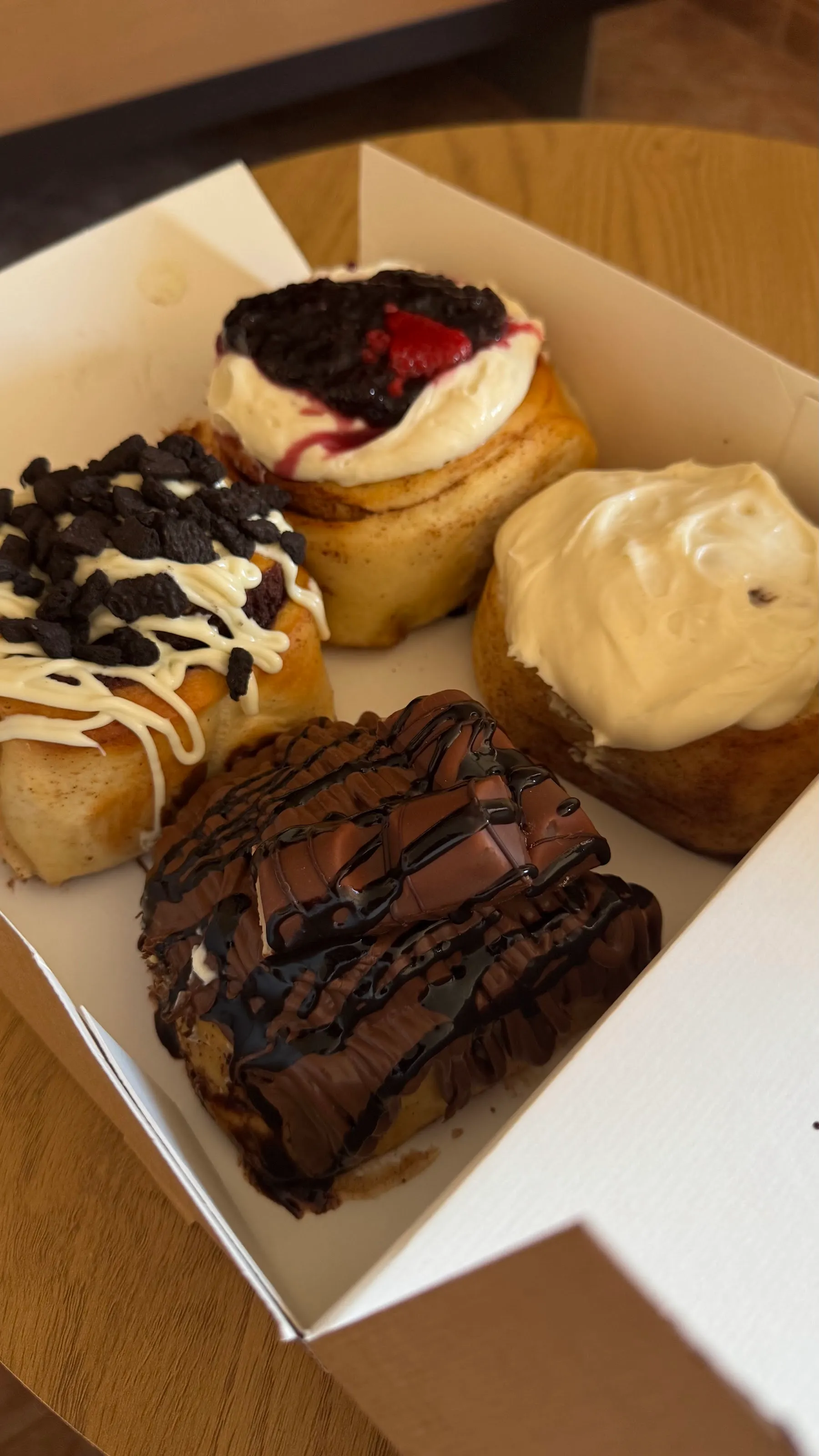 Caja blanca para llevar con cuatro rollos: Oreo, frutos rojos, glaseado y chocolate